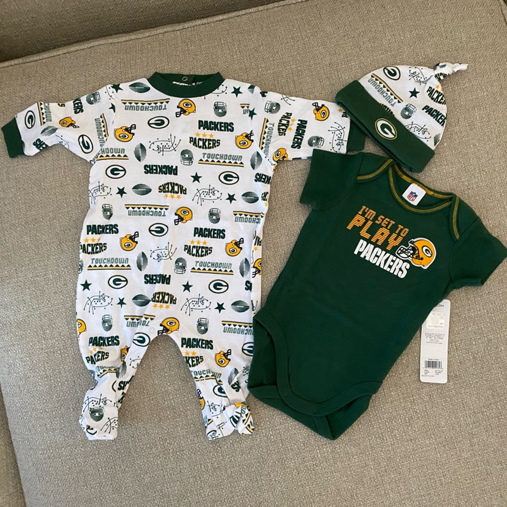 Packers bodysuit, one Sleep 'n Play, and cap